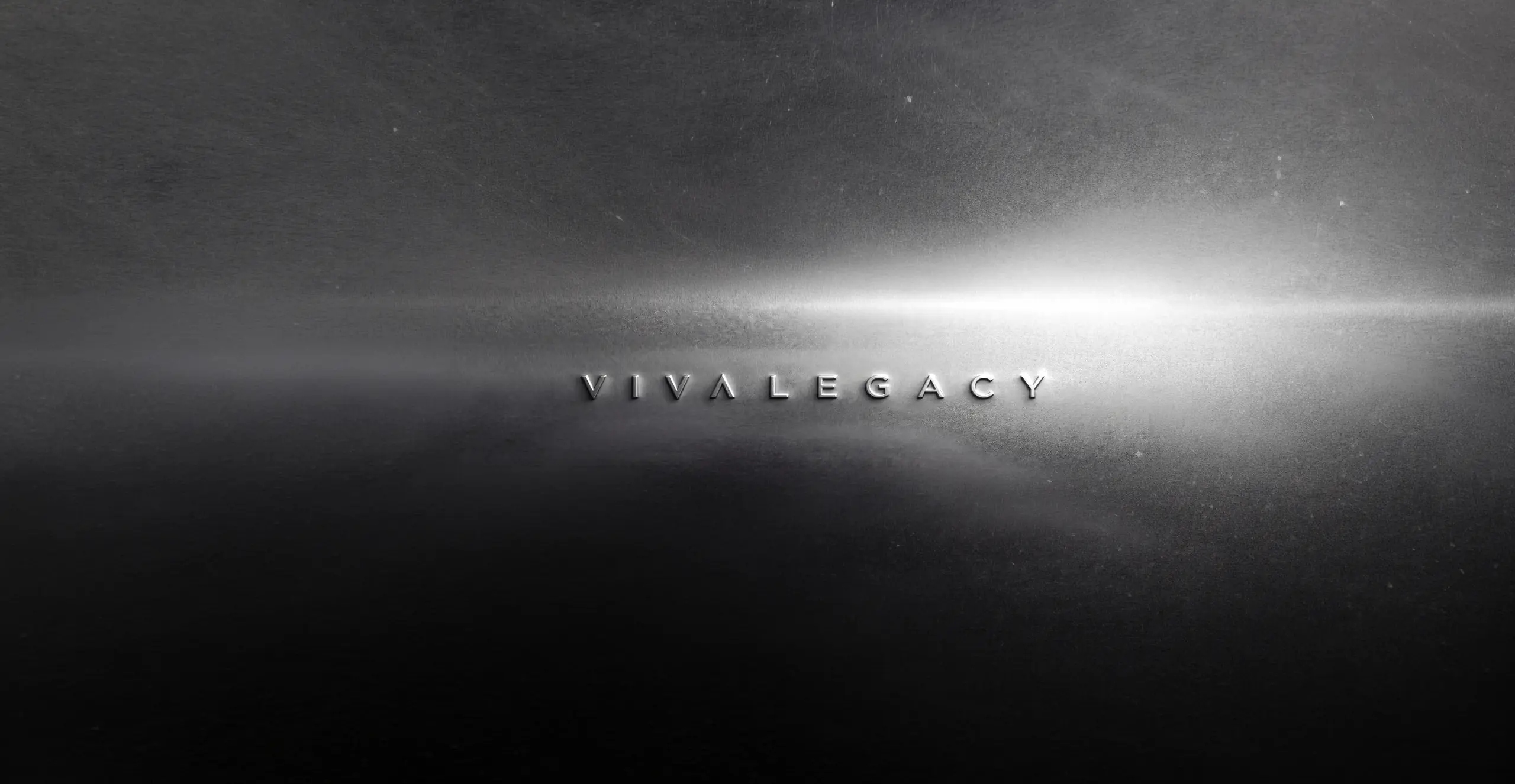 Logotipo VIVA LEGACY grabado en relieve sobre metal cepillado