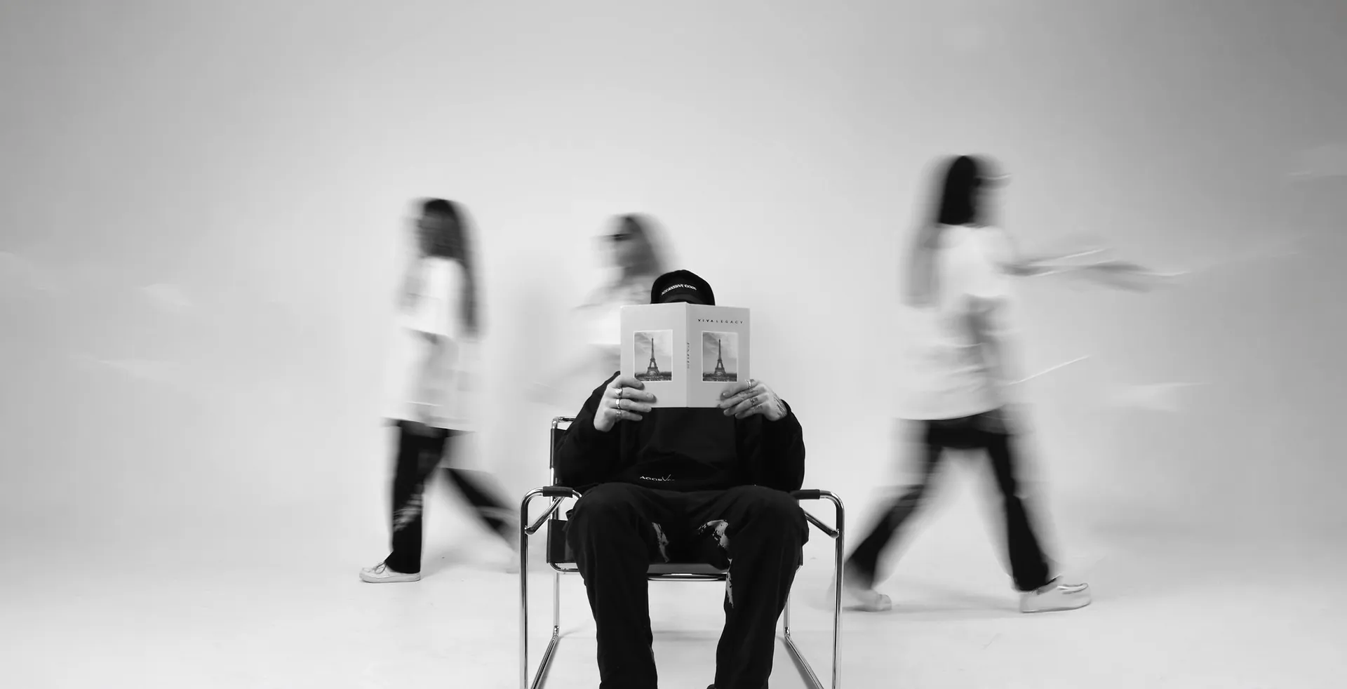 Figuras en movimiento desenfocado alrededor de una persona sentada, editorial VIVA LEGACY