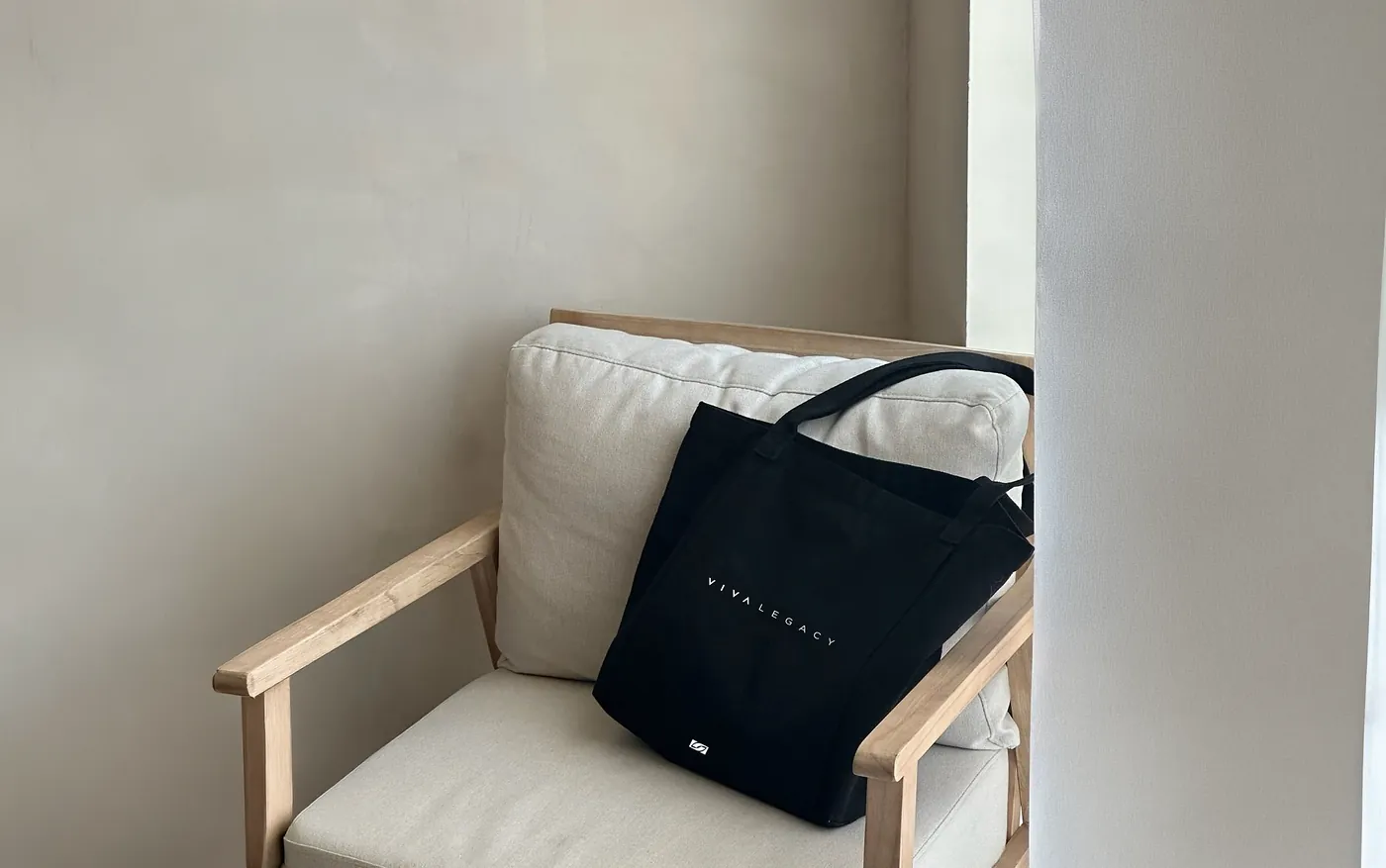 Tote bag negro VIVA LEGACY sobre un sillón